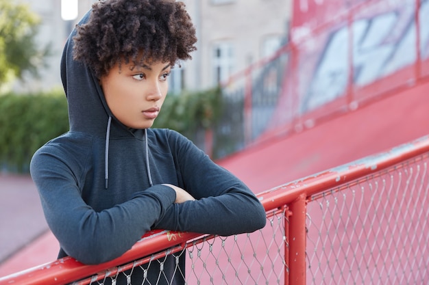 Free photo horizontal shot of thoughtful dark skinned female with afro haircut, sweatshirt