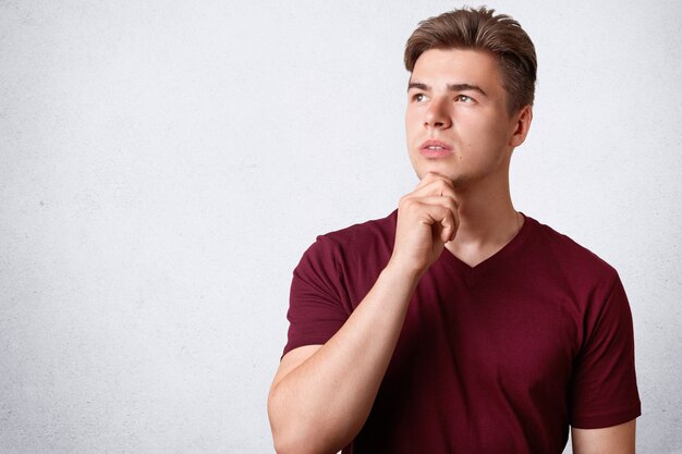 Horizontal shot of thoughtful male with appealing appearance and strong healthy body