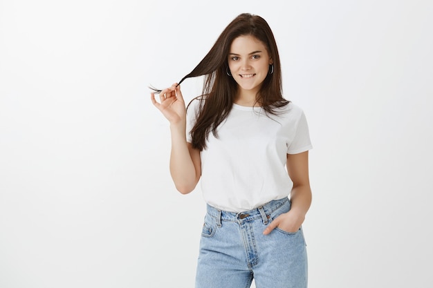 Horizontal shot of young woman posing against white wall