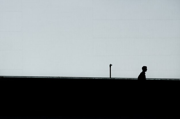 Horizontal silhouette of a lonely male under the clear sky