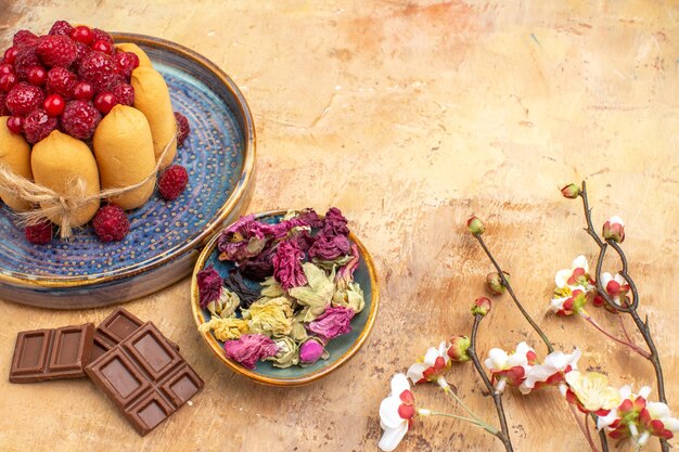 Free photo horizontal view of freshly baked soft cake with fruits flowers and chocolate bars