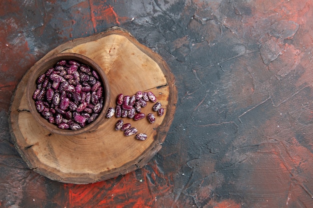 Horizontal view of instant pot black beans in a brown bowl on a wooden tray on mixed color table