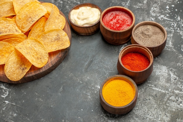 Horizontal view of potato chips spices and mayonnaise with ketchup on gray table