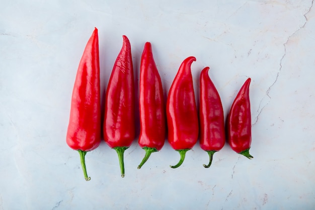 Horizontal view of red peppers on white background with copy space
