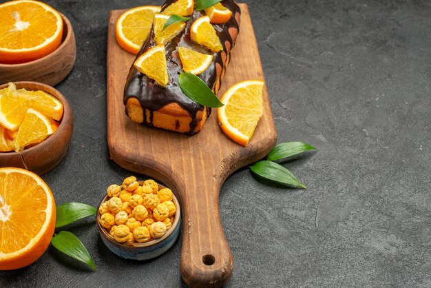 Horizontal view of set of cut in half sliced on pieces of fresh oranges and soft cakes 