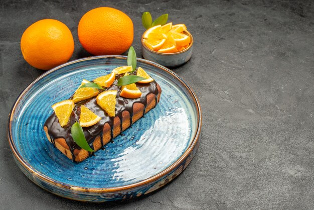 Horizontal view of soft delicious cake on tray and lemon on black table