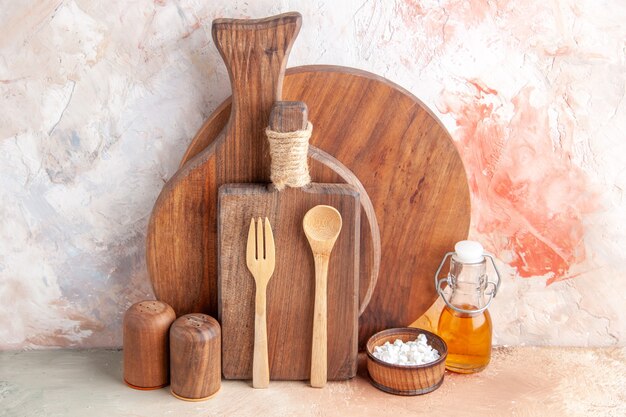 Horizontal view of various cutting boards wooden spoons small oil bottle on colorful wall