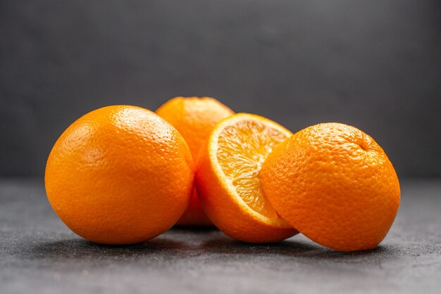 Horizontal view of whole and chopped fresh lemons on dark table 