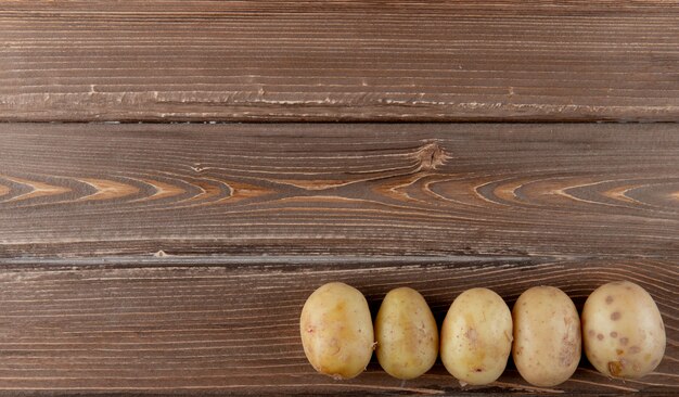 Горизонтальный вид всего картофеля на правой стороне и деревянный фон с копией пространства
