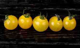 Free photo horizontal view of yellow tomatoes on wooden surface