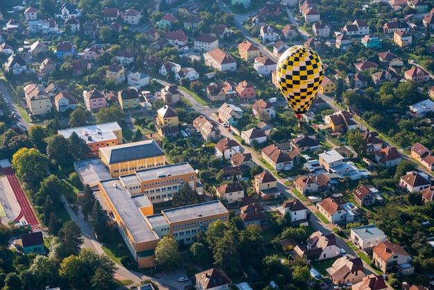 Free photo hot air ballon flying low above small czech city