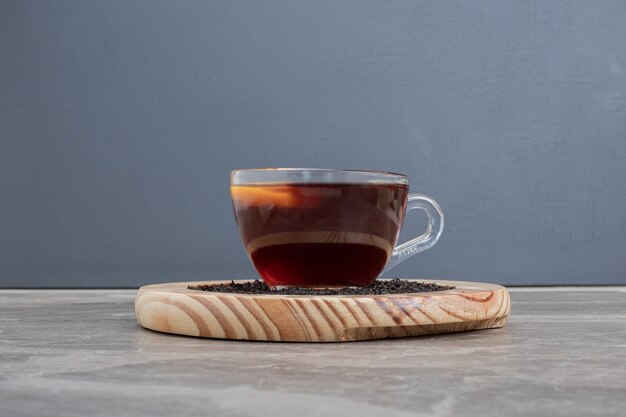 Hot, aroma tea on wooden plate on marble table.