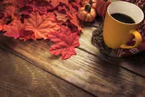 Free photo hot beverage and red maple leaves composition