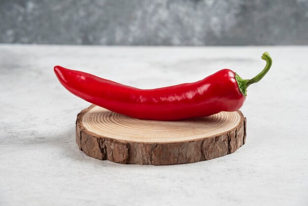 Hot chili pepper on wood piece.