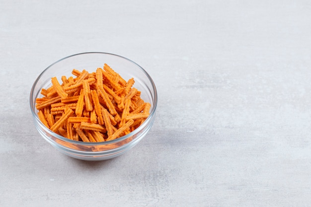 Hot chips in glass bowl over white.