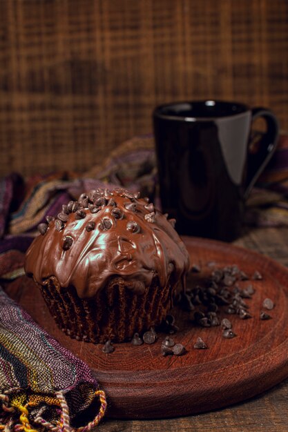 Hot chocolate mug and muffin on wood board