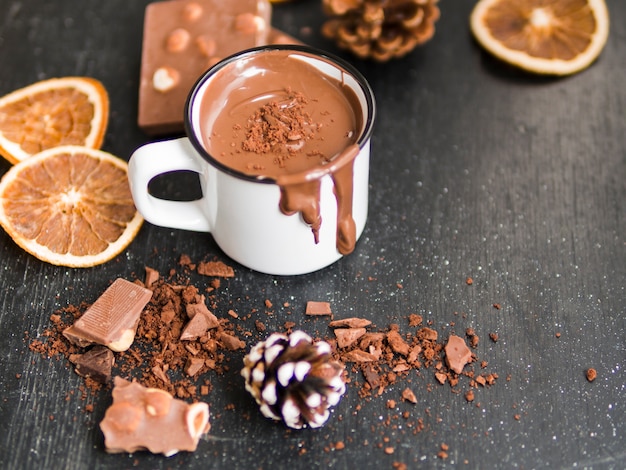 Hot chocolate near oranges and candy bar