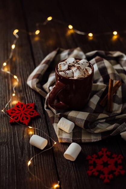 Hot chocolate with Marshmallows in a ceramic cup on brown wooden table