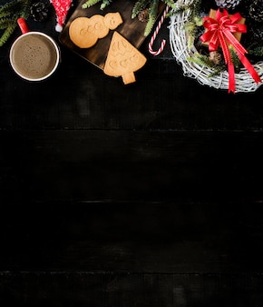 Горячий кофе для зимнего сезона со снегом. с рождеством и новым годом в отпуске. скопируйте пространство для текста на фоне черного дерева.