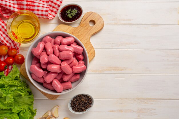 Hot dog or sausages on the white wooden surface.