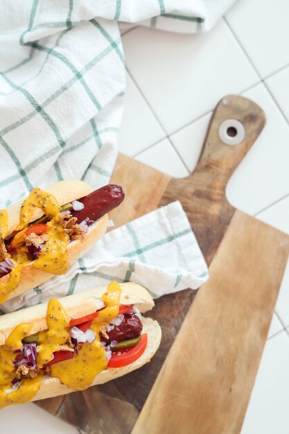 Foto gratuita hot dog con salsa sulla superficie bianca