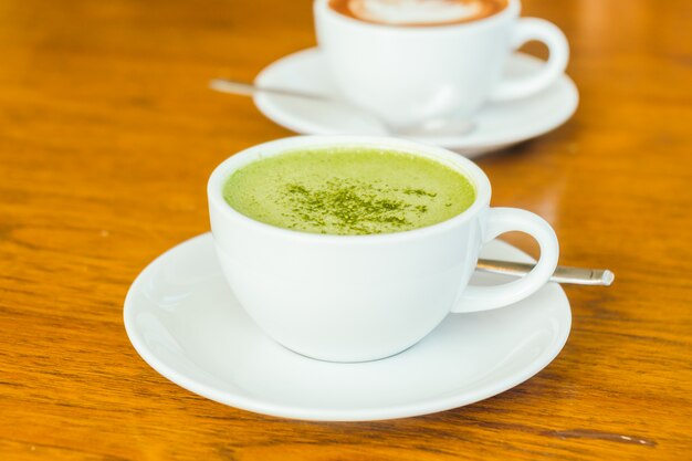 Hot green matcha latte in white cup