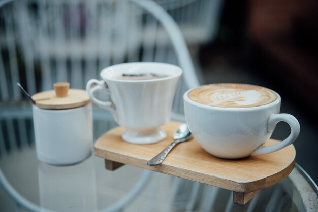 Hot latte art in coffee cup on wood table in coffee shop