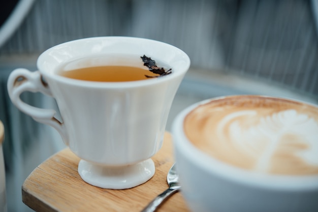 Hot latte art in coffee cup on wood table in coffee shop