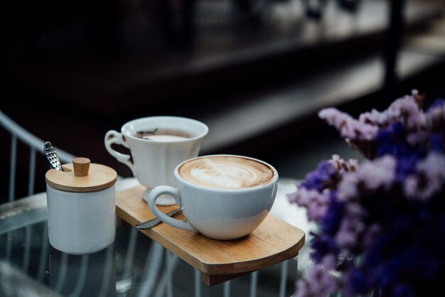 커피 숍에서 나무 테이블에 커피 컵에 뜨거운 라떼 아트