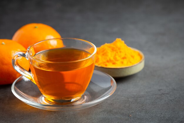 Hot orange tea and fresh orange on the table