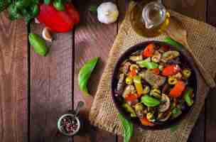 Foto gratuita spezzatino piccante speziato di melanzane, peperoni, olive e capperi con foglie di basilico. vista dall'alto