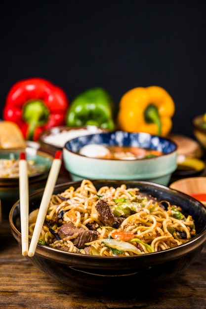 Hot and spicy stir fried instant noodle with beef and vegetable in ceramic bowl