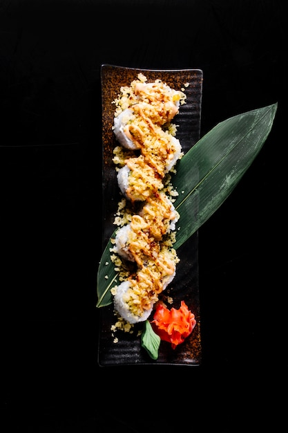 熱い寿司は生leafとわさびを添えて緑の葉の上で回転します。