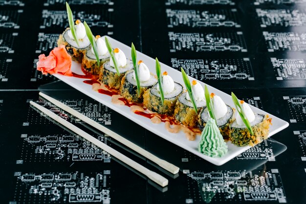 Hot sushi rolls topped with japanese mayonnaise red tobiko and scallion