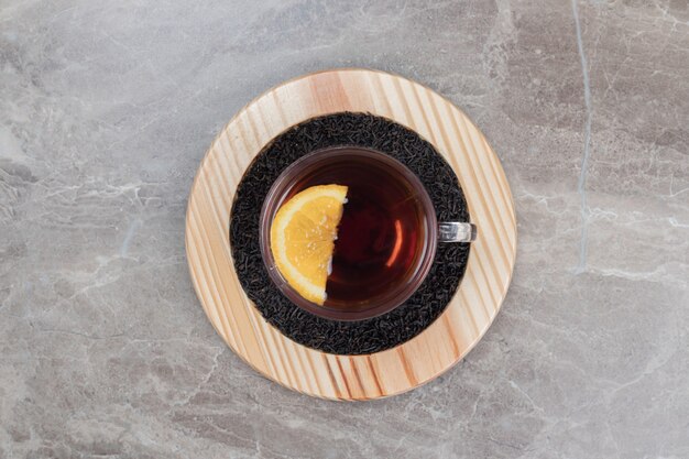 Hot tea with lemon on wooden plate