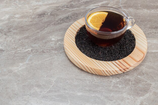 Free photo hot tea with lemon on wooden plate