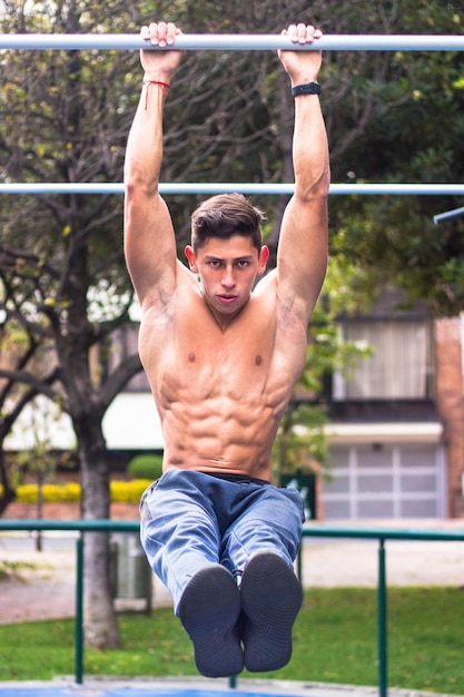 hot young muscular man working out on horizontal bars