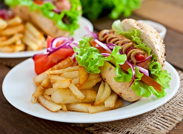 Hotdog with ketchup mustard and lettuce on wooden table.