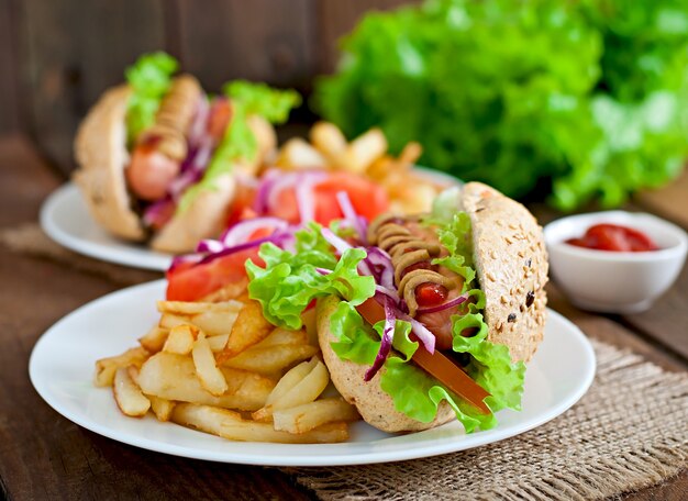 Hotdog with ketchup mustard and lettuce on wooden table.