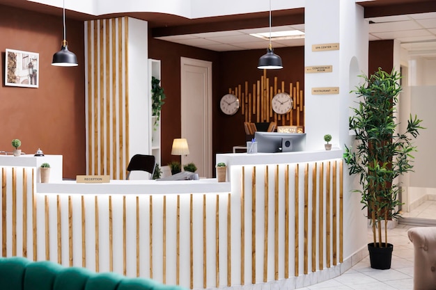 Foto gratuita lobby dell'hotel con un design impressionante e mobili moderni, costosi alloggi in resort con pavimenti in marmo. reception vuota con computer e campanello di servizio, registrazione.