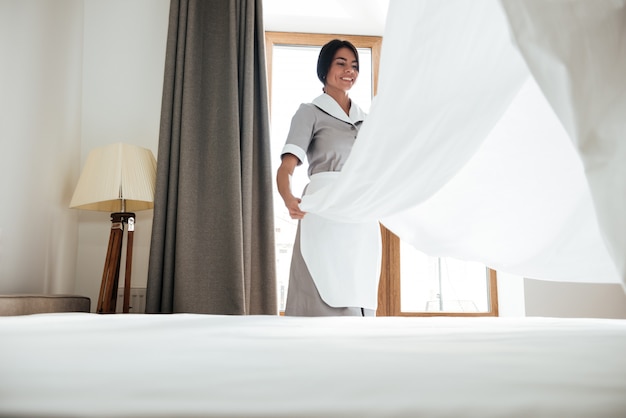 Free photo hotel maid changing bed sheet