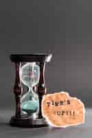 Free photo hour glass with time's up text on black surface