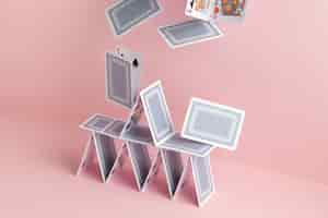 Free photo house of cards falling on pink background