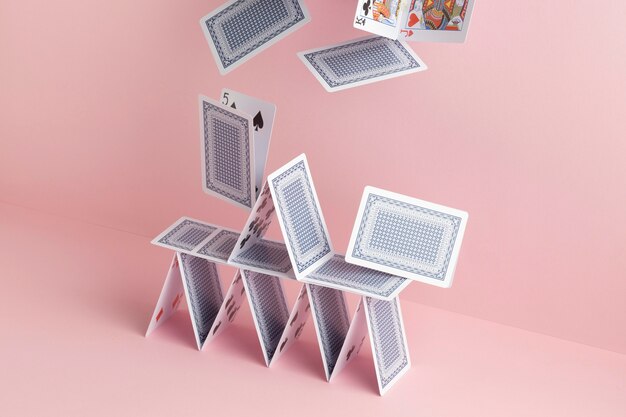 House of cards falling on pink background