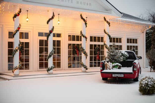 House decorated for Christmas with red car.