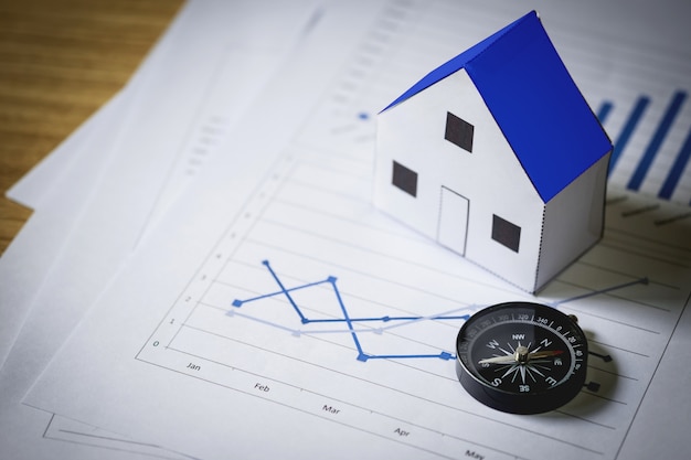 House model and compass on plan background, Real estate concept