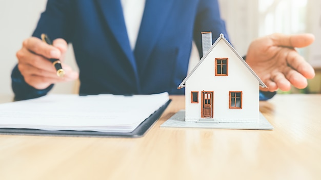 부동산 중개인 및 주택, 보험 또는 대출 부동산 개념을 구매하는 계약에 대해 논의하는 고객이있는 주택 모델