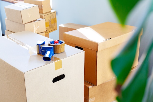 Концепция перемещения дома с сложенными картонными коробками в комнате