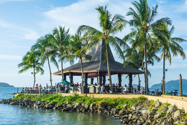 House between palm trees and sea