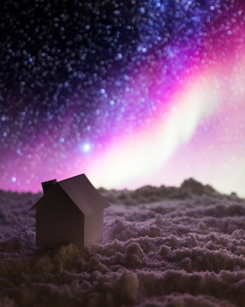 House on snow with aurora borealis